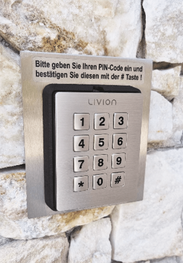 Nummerncodeschloss für PIN-Eingabe mit Edelstahlrahmen an einer Steinwand montiert Nummerncodeschloss für PIN-Eingabe mit Edelstahlrahmen an einer weißen Wand montiert