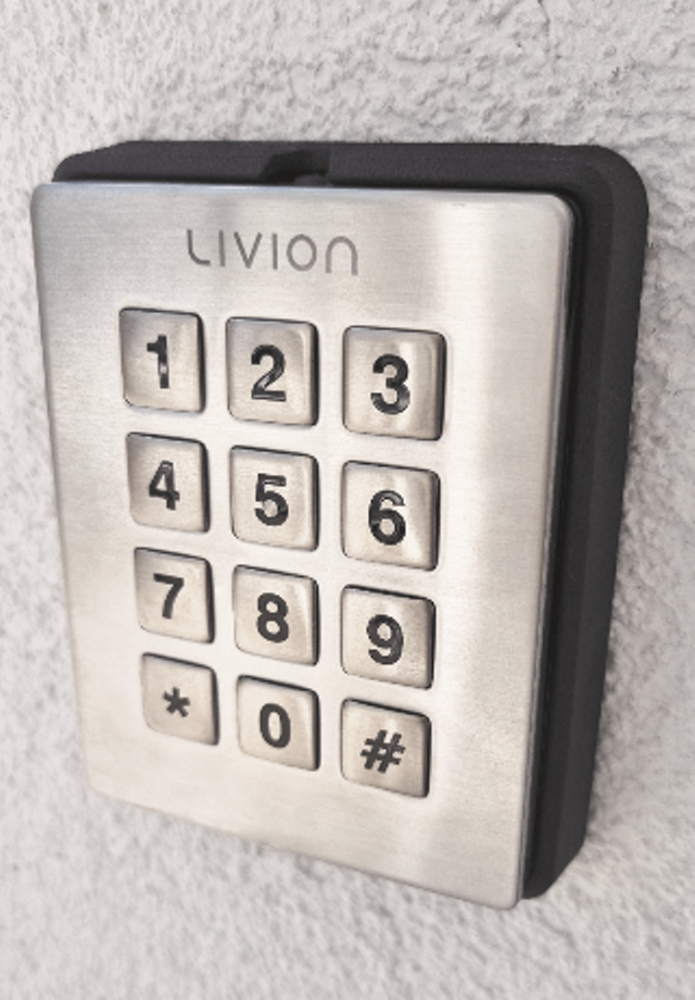 Metallene Tastenfeld-Verkleidung für Zugangskontrolle an einer Wand Nahaufnahme eines metallenen Tastenfelds mit Ziffern und Symboltasten an einer Wand montiert, verwendet für Zugangskontrollsysteme