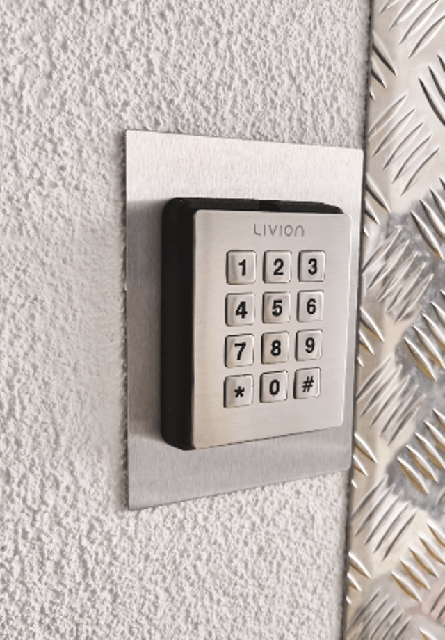 Nummerncodeschloss für PIN-Eingabe mit Edelstahlrahmen an einer weißen Wand montiert Nummerncodeschloss für PIN-Eingabe mit Edelstahlrahmen an einer weißen Wand montiert