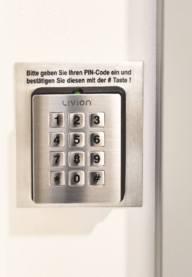 Nummerncodeschloss für PIN-Eingabe mit Edelstahlrahmen an einer weißen Wand montiert